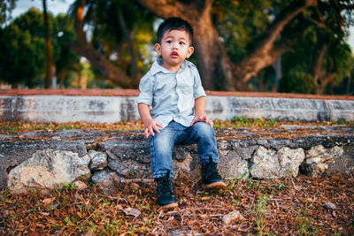 Full length portrait of boy sitting outdoors