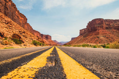 Surface level of road amidst rock formation against sky