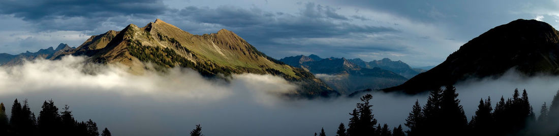 Scenic view of mountains against cloudy sky