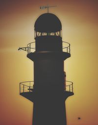 Low angle view of silhouette tower against sky during sunset