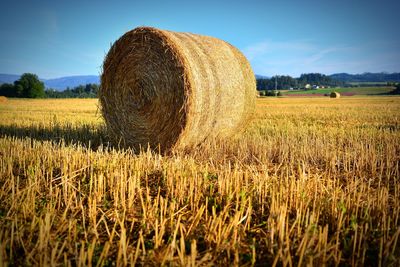 Hay bales on field against sky