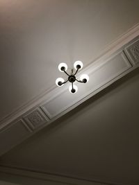 Low angle view of illuminated chandelier hanging on ceiling