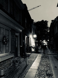 Street amidst buildings in city at dusk