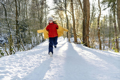 Full length of woman on snow in forest