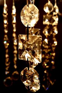 Close-up of illuminated lighting equipment hanging at night