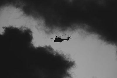 Low angle view of silhouette airplane against sky