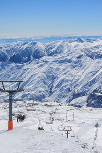 Chairlift on the background of snow ridges and blue sky. the concept of active winter recreation