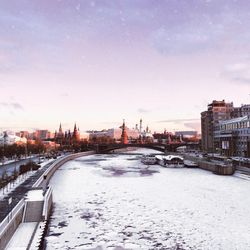 Snow covered cityscape against sky at night