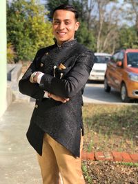 Portrait of smiling young man standing in city