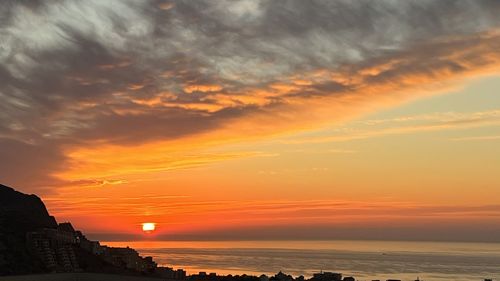 Scenic view of sea against orange sky