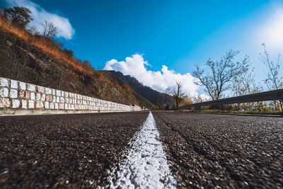 Surface level of empty road against blue sky