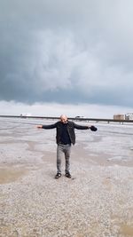 Full length of man standing on beach against sky