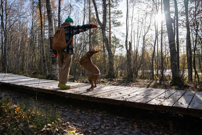 Rear view of woman standing on footbridge