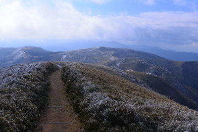 Scenic view of mountains against cloudy sky