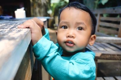 Close-up of a beautiful brown eyed asian toddler while practicing standing and walking