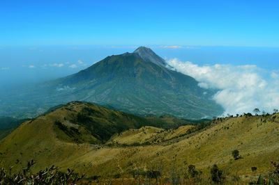 Scenic view of mountains against blue sky