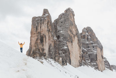 Low section of person standing on snow covered mountain