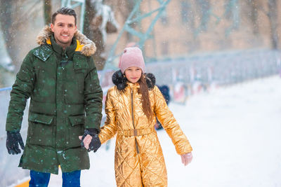 Portrait of smiling young woman standing in snow