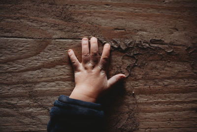 Close-up of hand touching wall