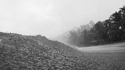 Road by mountains against sky during rainy season