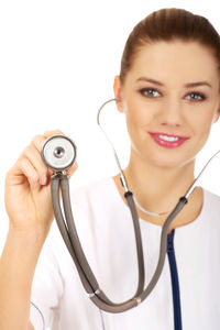 Portrait of female doctor holding stethoscope against white background