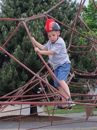 Side view of boy standing against trees