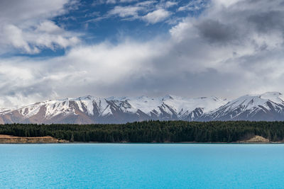 A scenic landscape of new zealand southern alps and lake pukaki with blue sky and clouds.