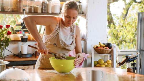 Woman preparing food in kitchen at home