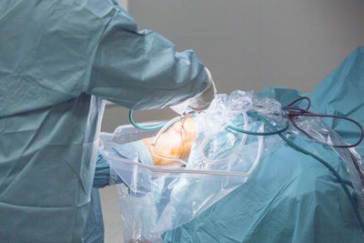 Midsection of surgeon operating knee in hospital