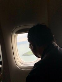 Portrait of man looking through airplane window