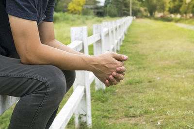 Midsection of man with arms raised on field