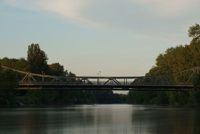 Bridge over river against sky during sunset