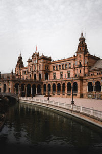 Arch bridge over river against buildings