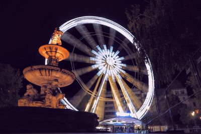 Low angle view of illuminated ferris wheel at night