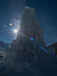 Low angle view of illuminated snow against sky during winter