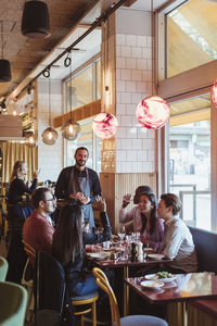 Male and female friends having dinner at restaurant afterwork