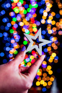 Midsection of person holding christmas lights