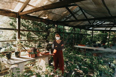 Full length of woman standing in greenhouse