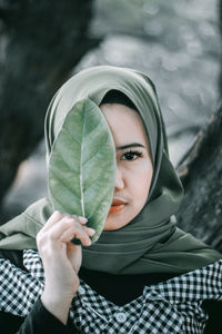 Close-up of woman holding leaf