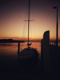 Silhouette boat sailing on sea against clear sky during sunset