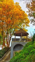 Arch bridge amidst trees against sky during autumn