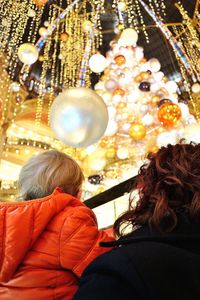 Rear view of people in illuminated amusement park