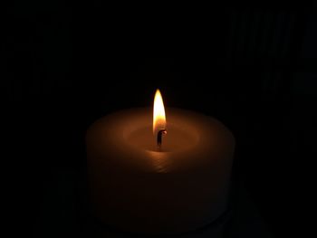 Close-up of lit candle in dark room