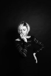 Portrait of a beautiful young woman over black background