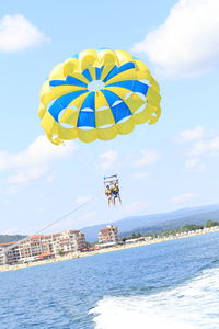 View of kite flying over sea against sky