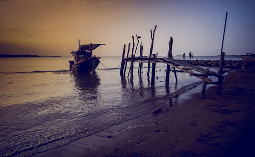 Nautical vessel on sea against sky during sunset