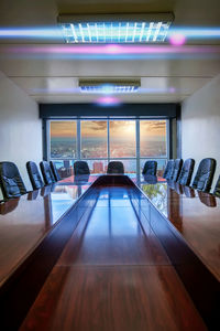 Empty chairs and tables in illuminated room