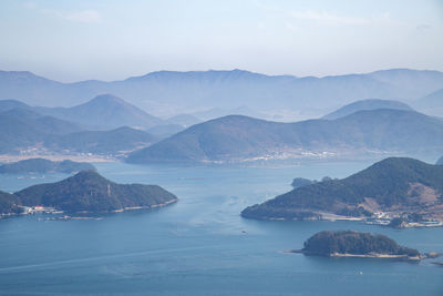 Scenic view of sea by mountains against sky