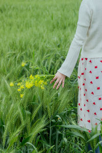 Midsection of woman standing amidst plants