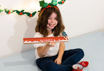 Happy girl with advent calendar ruler in her hands.